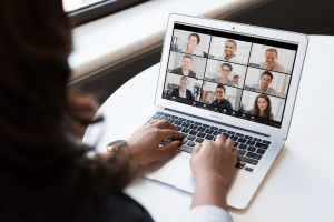 a computer that has 9 people on the screen having a virtual meeting