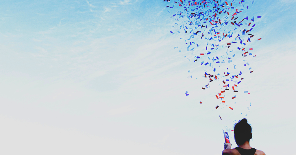 a women outside popping a confetti popper to celebrate the collaboration in her team