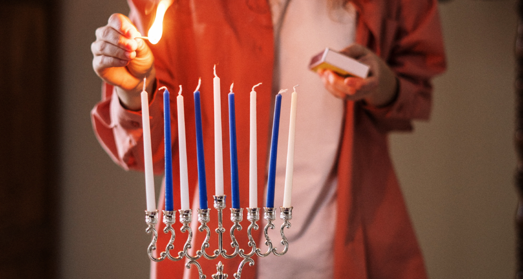 someone lighting a menorah