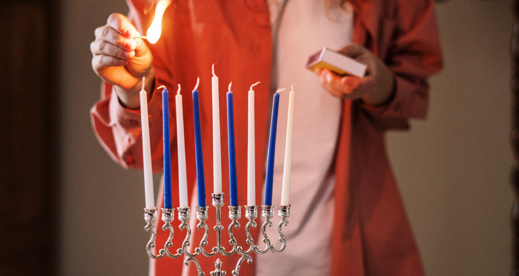 someone lighting a menorah 