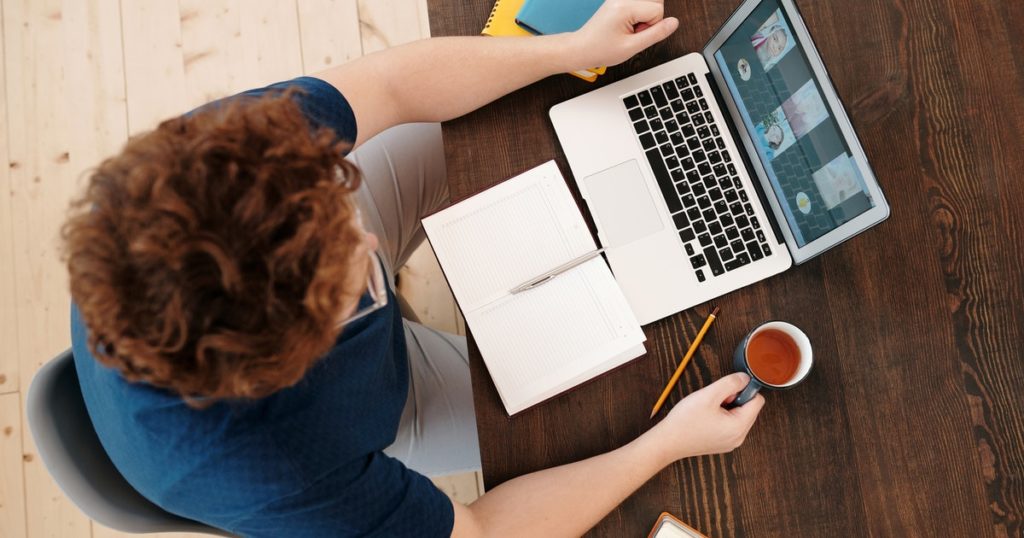 Top down view of someone at their laptop interacting in a virtual meeting