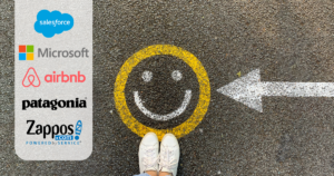 top down view of a smiley face painted on pavement. A painted arrow point at it from the right. On the left a side panel of companies that value employee wellbeing