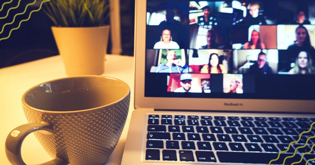 A coffee mug with a laptop that is logged into a zoom meeting
