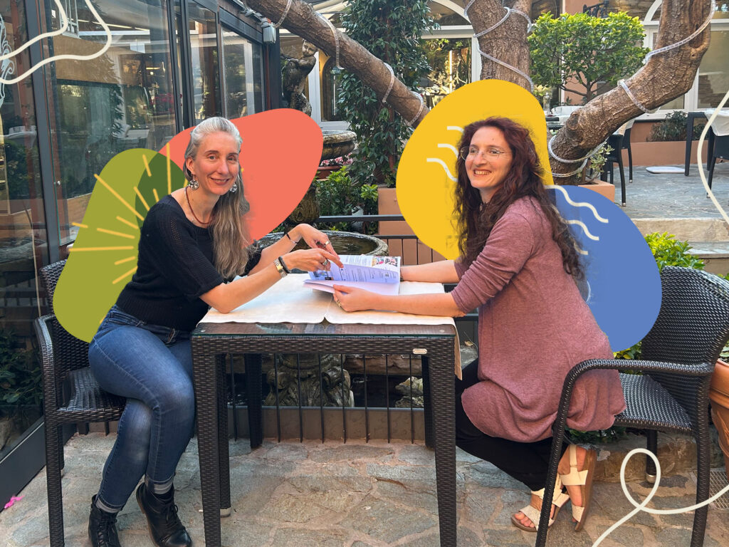 Ginny Santos and Marina Randich sitting at a table together planning the next UPWELL Session