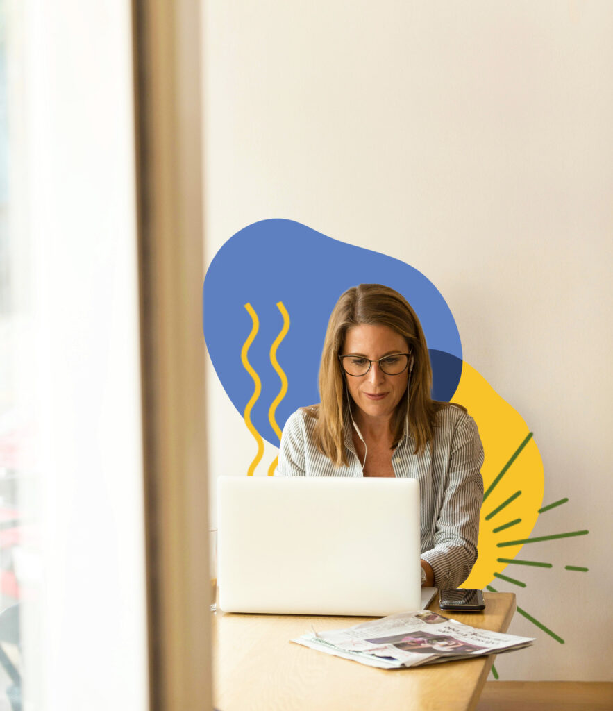 A women sitting at a laptop with headphones in.